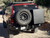 Rear view of an red Excursion van on the wild featuring Aluminess Rear Bumper.
