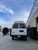 Rear view of a white Express van featuring Aluminess Rear Bumper with swing arms open parked on the street.