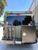 A graphite-colored Nissan NV van with an off-road rear bumper and accessories from Aluminess Products.