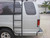 Silver Ford E-Series van equipped with a black side ladder.