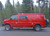 Red Chevy Express van with an all-aluminum side ladder from Aluminess Products on the driver side of the vehicle.