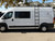 White Dodge RAM Promaster van with a side ladder and roof rack from Aluminess Products.