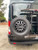 Rear view of a black Ford Transit van featuring Aluminess Driver Side Rear Door Box/Tire Rack.