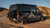 Fiamma Roof Rack Awning mounted on a Transit van parked on rocky terrain.
