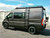 Black Dodge RAM Promaster van featuring Aluminess Touring Roof Rack parked on the street.