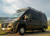 Black Dodge RAM Promaster featuring Aluminess Touring Roof Rack parked in the desert.