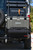 Rear view of the PowerLift Trail Caddy mounted on a van, carrying a cooler and an axe.
