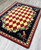 American Dakota High Country Rooster Red rug with red and cream diamonds and a dark rooster-and-rose border