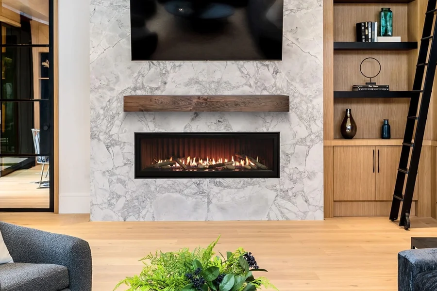 Linear gas fireplace in a marble feature wall beneath a wood mantel, beside built-in shelving