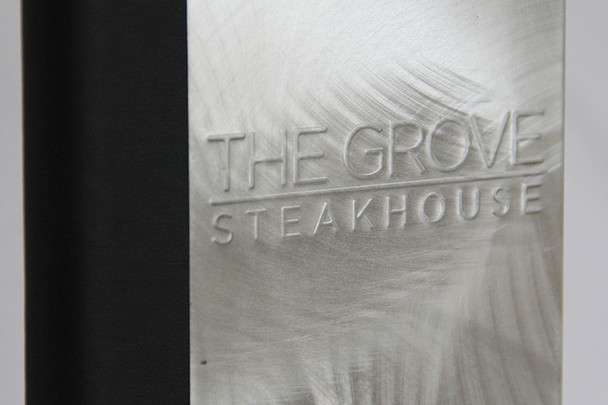 Embossed logo on an aluminum menu cover.