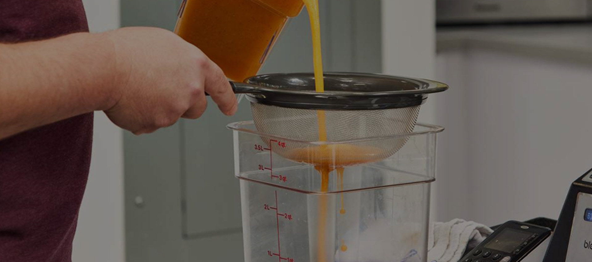 person pouring a smoothie from a blendte blender