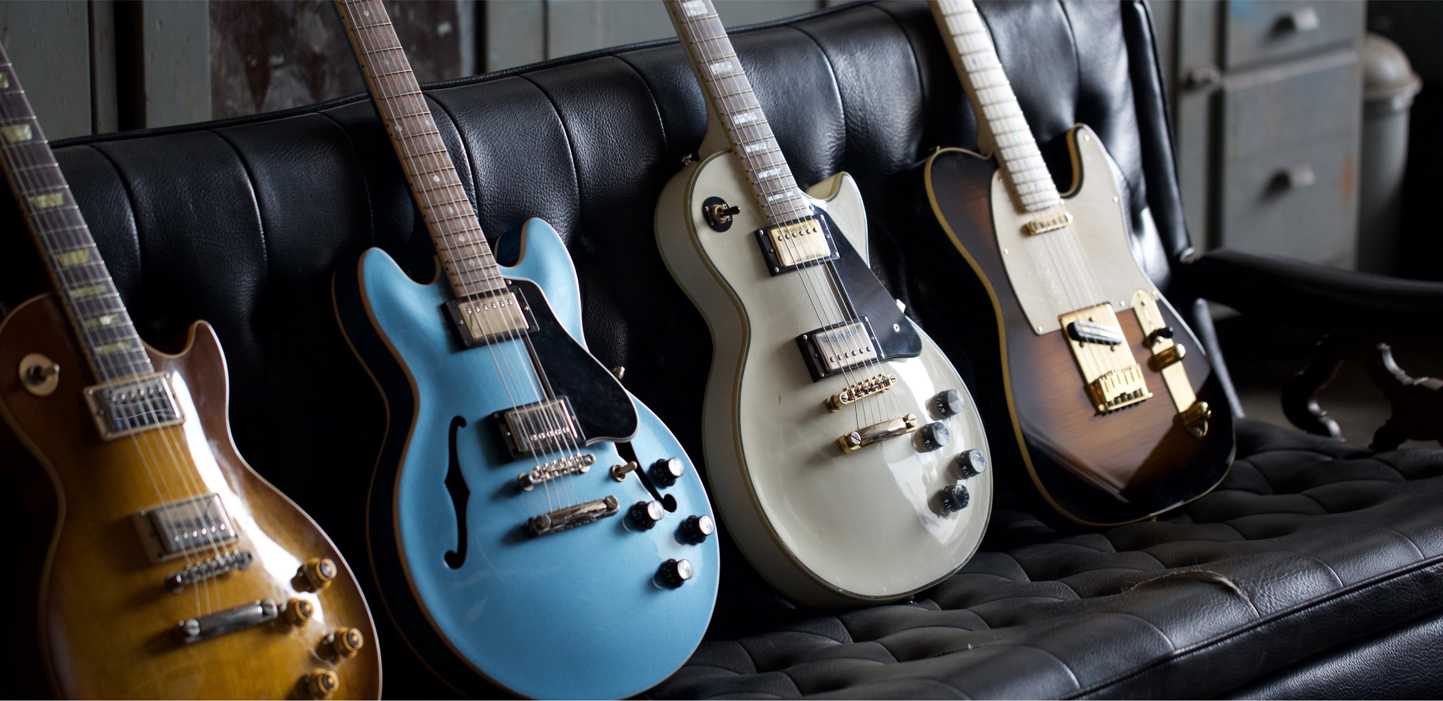 Multiple Electric Guitars on a leather couch