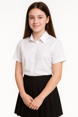 A teenage girl, approximately 14 years old, is shown wearing the Ayra Girls' Short Sleeve School Blouse in white, paired with a classic black pleated school skirt. The blouse is crisp and smart, featuring a clean, pocketless design ideal for school uniform requirements. This image is set against a pure white background, offering a clear and professional view of the product fit and style—perfect for showcasing the blouse as part of a complete school uniform.