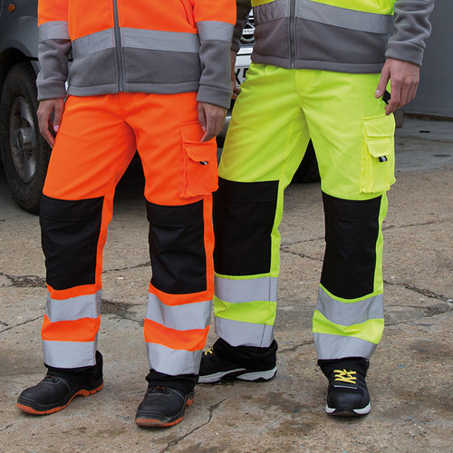 Hi vis orange cargo work trousers with wide reflective bands, knee pad pockets and dark panels