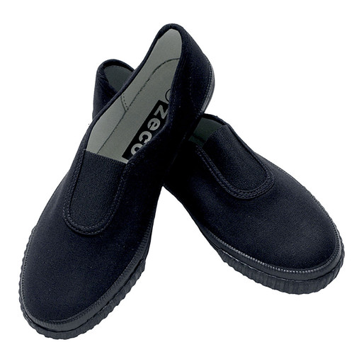 Gusset Plimsoles (Zeco) (PL3218) Black. Child wearing black slip-on school plimsolls with elastic gussets, standing on a sports hall floor in PE kit