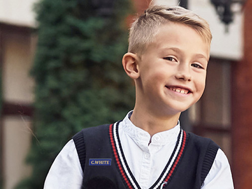 Boy in school uniform with an Easy2Name ID name tag on his jumper