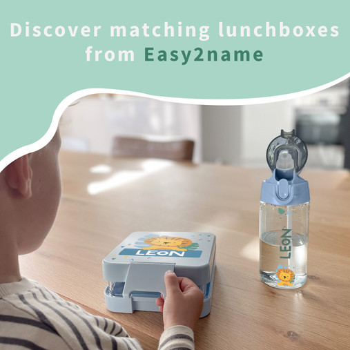 Child at a table with a personalised lunch box named Leon and a matching water bottle
