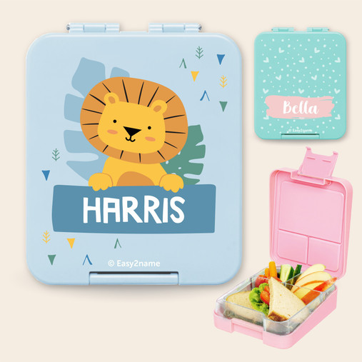 Light blue personalised kids lunch box with a lion picture and the name Harris, and a pink lunch box open to show its compartments