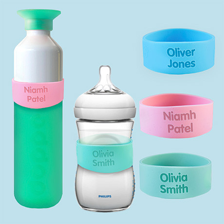 Personalised silicone bottle name bands in blue, pink and green on a sports bottle and a baby bottle, named Oliver Jones, Niamh Patel and Olivia Smith