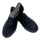 Gusset Plimsoles (Zeco) (PL3218) Black. Child wearing black slip-on school plimsolls with elastic gussets, standing on a sports hall floor in PE kit