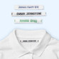 Easy2Name woven sew-on name tapes in blue, black and green, sewn into a white school polo shirt