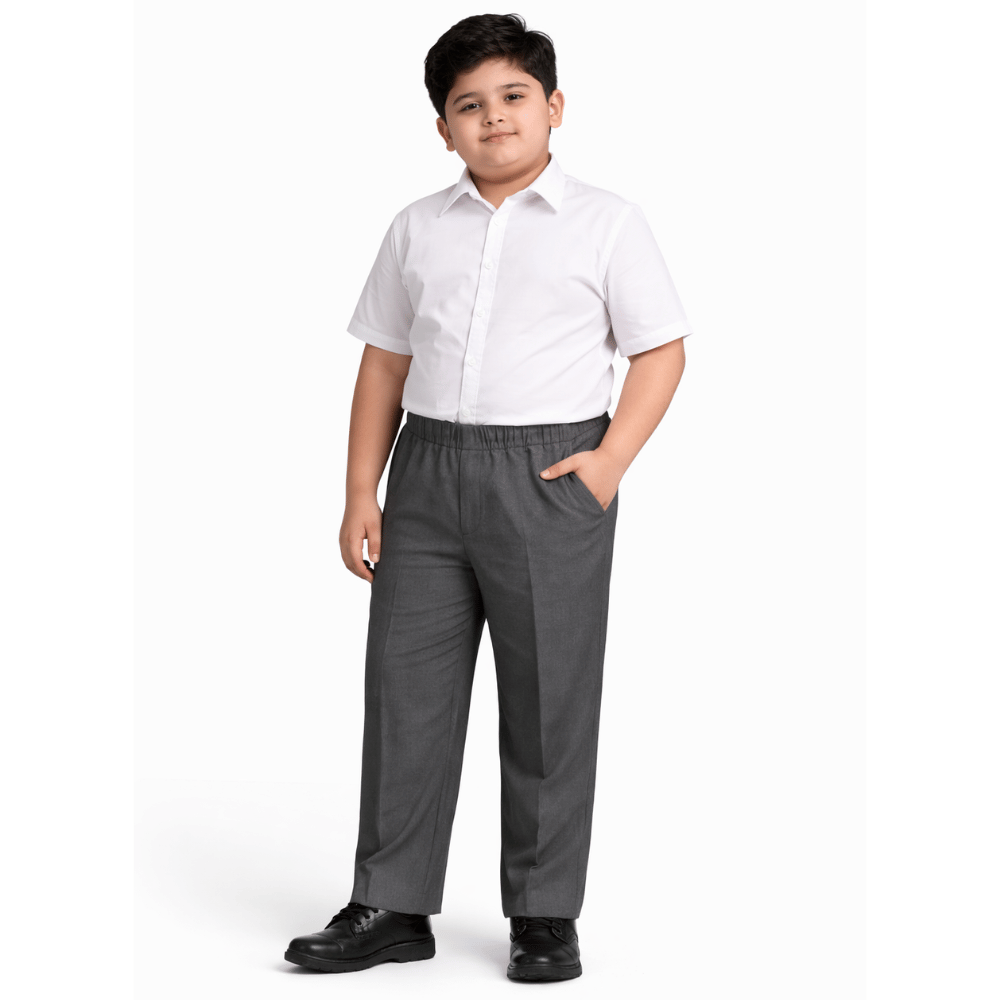 Boy wearing grey plus fit elastic waist school trousers with white school shirt and black shoes full length view