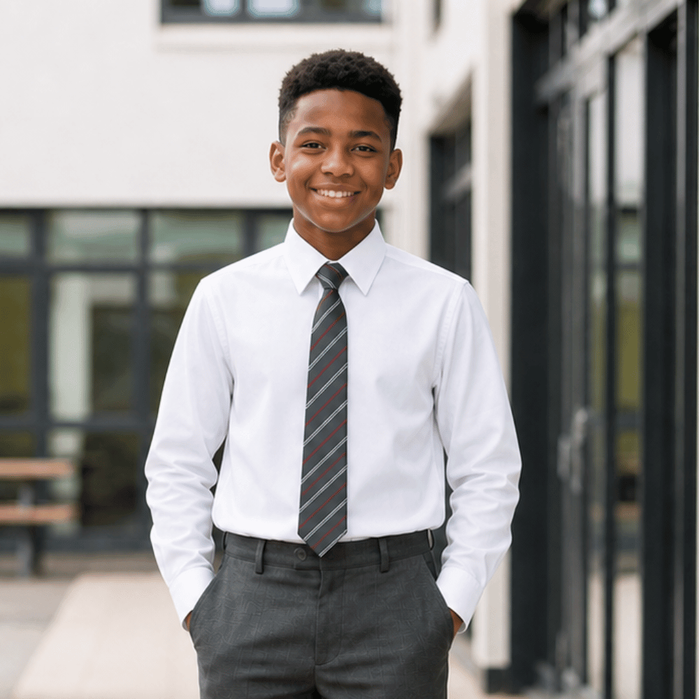 Boy wearing white long sleeve non iron school shirt with grey trousers and school tie