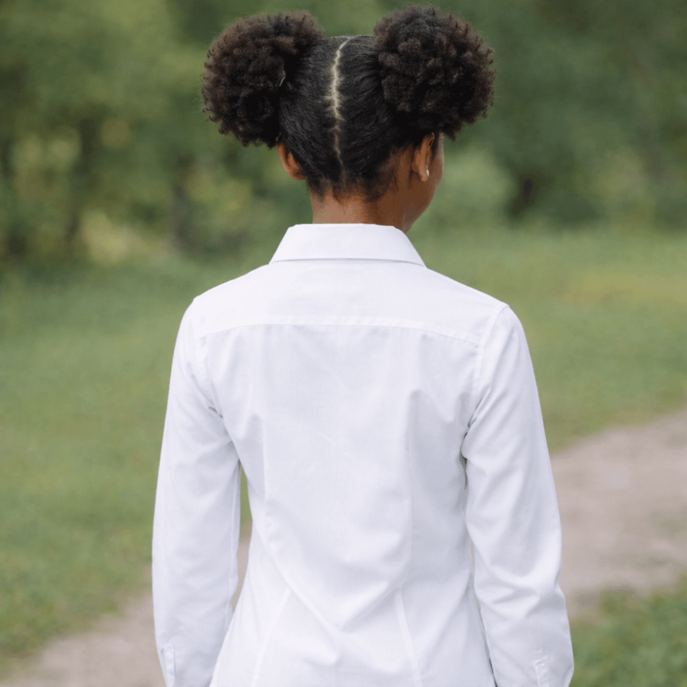 Back view of girl in white school blouses and school uniform in outdoor setting