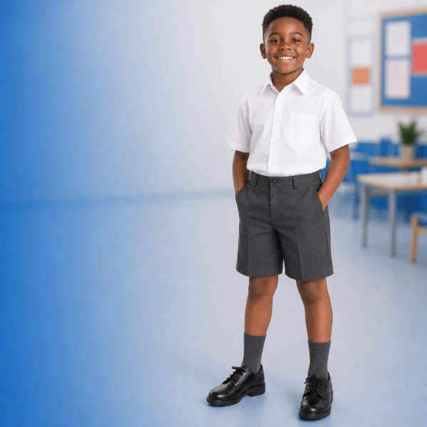 Boy wearing grey boys school shorts and white school shirt in classroom