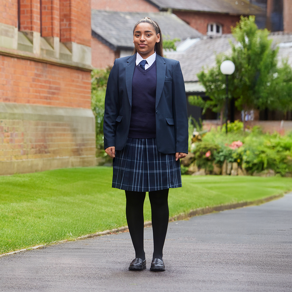 Lifestyle image – student wearing the Banner Tartan Pleated Skirt in Navy Tonal