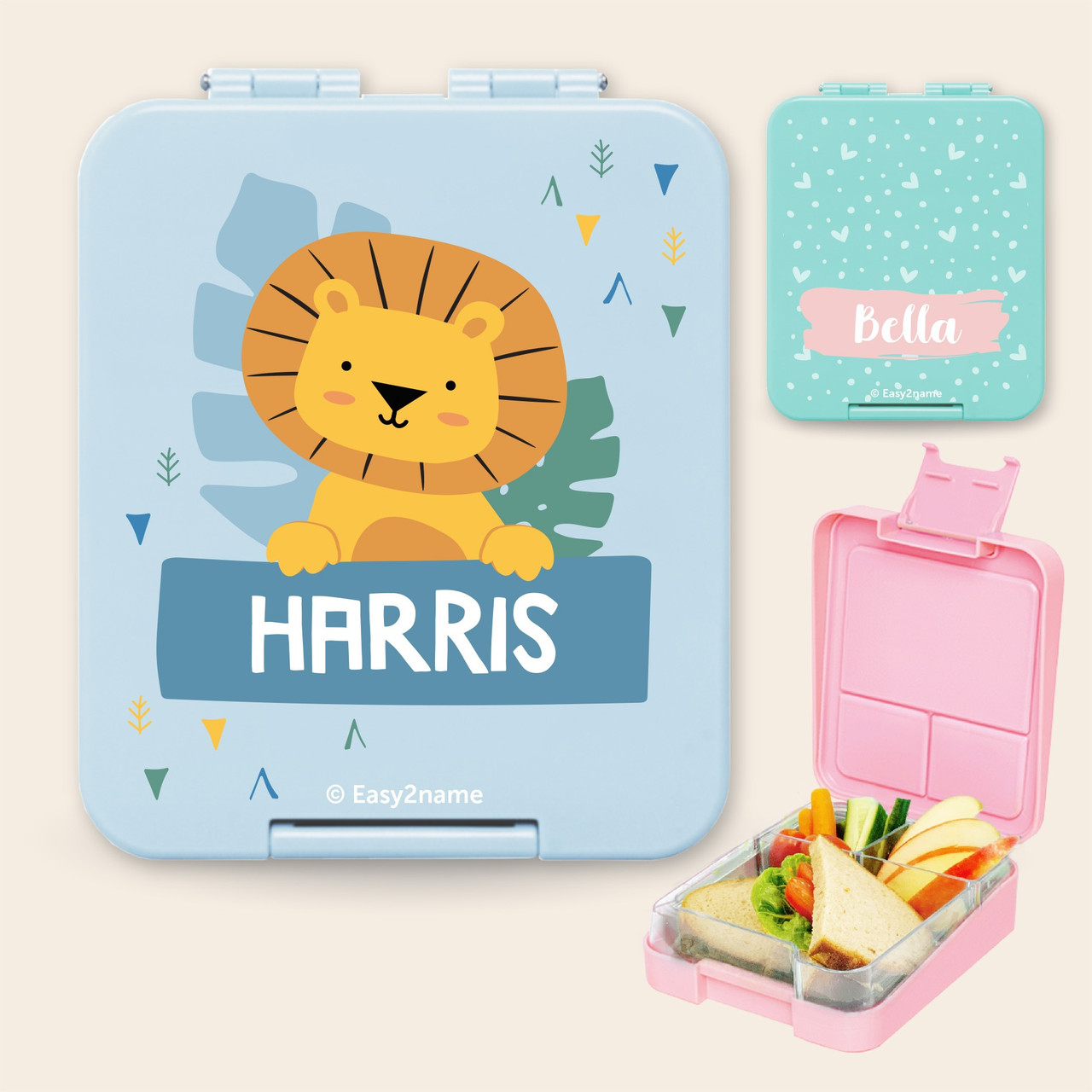 Light blue personalised kids lunch box with a lion picture and the name Harris, and a pink lunch box open to show its compartments