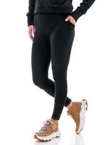 Front view of woman modeling black Aventura Clothing Dog Walker Fleece Legging, hand in side pocket.