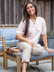 Woman sitting on chair outside wearing Ballard Ankle Pant in tan