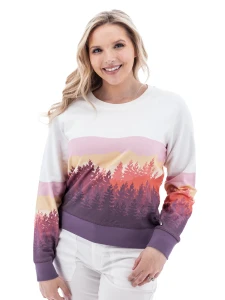 Woman wearing white Aventura Clothing Alpine Glow Sweatshirt with pink, orange, and purple mountain sunset print.