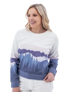 Woman wearing white Aventura Clothing Alpine Glow Sweatshirt with blue and purple mountain silhouette print.