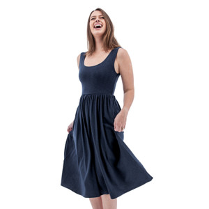 Laughing woman swishing the full skirt of the navy Aventura Clothing Linden Fit & Flare Tank Dress.