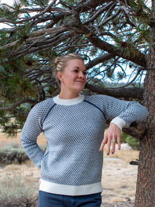 Woman standing outdoors wearing the Bridie Birdseye Crew Neck Raglan Sweater in snow white.