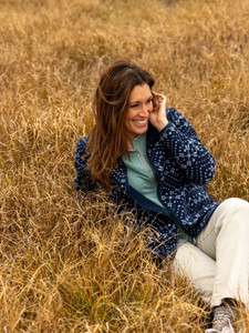 Woman laying in field during fall wearing the Celestra Organic Cotton Button Front Blouse in silver pine green.