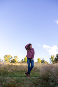 Woman standing outside during fall wearing the Cascade Cowl Neck Striped Pullover in wild ginger purple.