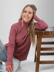 Woman sitting with stool wearing the Cascade 1/4 Zip Striped Pullover in wild ginger purple.