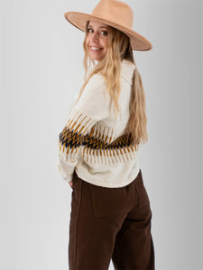 Left rear shoulder view of the Snowdrop Johnny Collar Jacquard Sweater in white with brown jacquard pattern print.