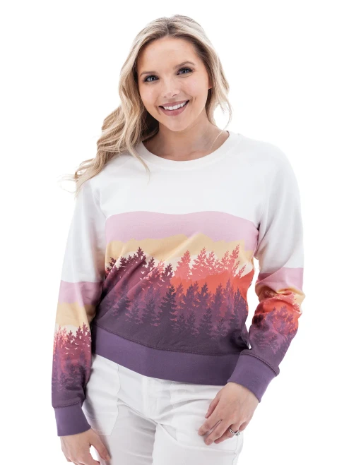 Woman wearing white Aventura Clothing Alpine Glow Sweatshirt with pink, orange, and purple mountain sunset print.