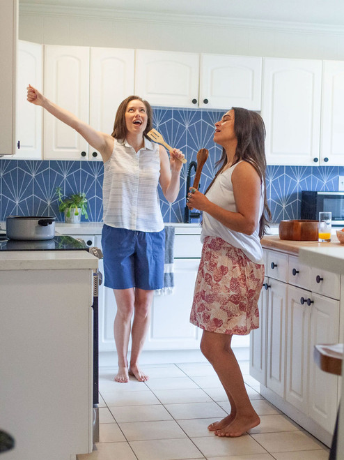 Woman dancing in kitchen wearing Kassie Pull-On Printed Skirt in Dusty Rose Red