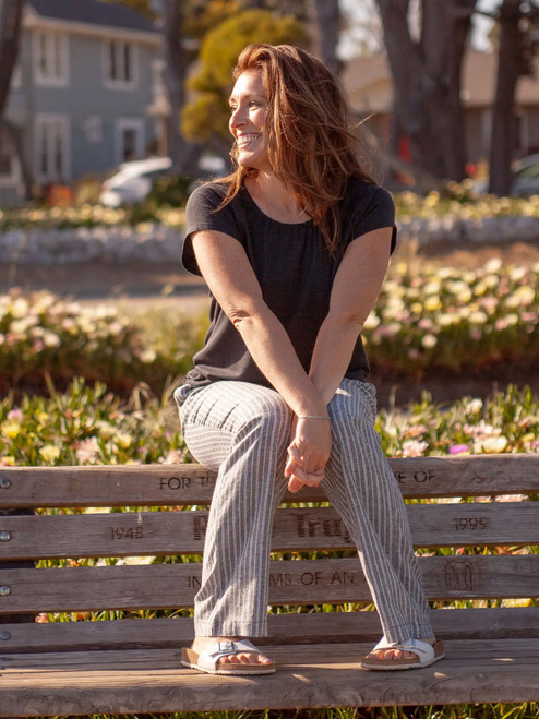 Woman sitting on bench wearing Breezy Striped Pull On Pant in Black