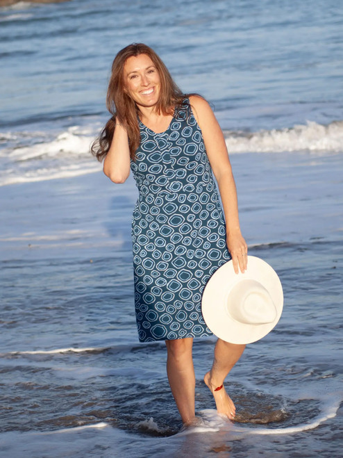 Woman walking on beach wearing Aventura Clothing Cali Fit & Flare Printed Dress in blue geometric circle pattern.