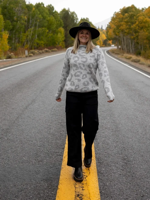 Woman standing in road during fall wearing the Sasha Animal Jacquard Mock Neck Sweater in heather grey print.