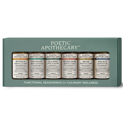 The image shows a premium slate-green gift box featuring a wide rectangular window that displays a row of six clear glass spice jars. Centered above the window, the brand name "POETIC APOTHECARY™" is printed in elegant white serif type, while the tagline "FUNCTIONAL SEASONINGS for CULINARY WELLNESS" runs across the bottom of the box. Each jar is topped with a copper-colored metallic lid and features a minimalist cream label with a distinct color-coded bar corresponding to its specific blend. From left to right, the collection includes Mythos for Strength & Clarity with a golden-ochre accent, Enchant for Heart & Elevation with a seafoam-green accent, and Eclipse for Focus & Ground with a slate-gray accent. These are followed by Petrichor for Renewal & Earth with a terracotta accent, Muse for Creative & Clarity with a champagne-gold accent, and Solace for Digestive Ease with a slate-blue accent. The jars reveal a variety of textures, ranging from finely ground, rich earthy spices to coarse botanical blends with visible leaf fragments and floral flecks.