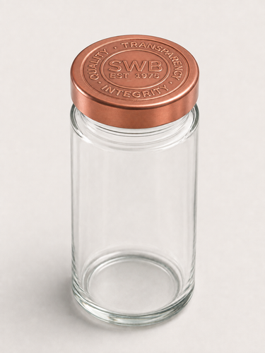 Empty clear glass spice jar with copper colored Starwest Botanicals branded lid.