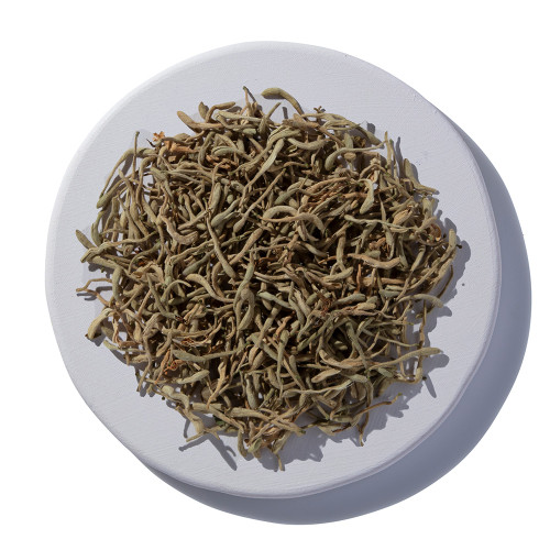 Dried honeysuckle flowers on a white plate