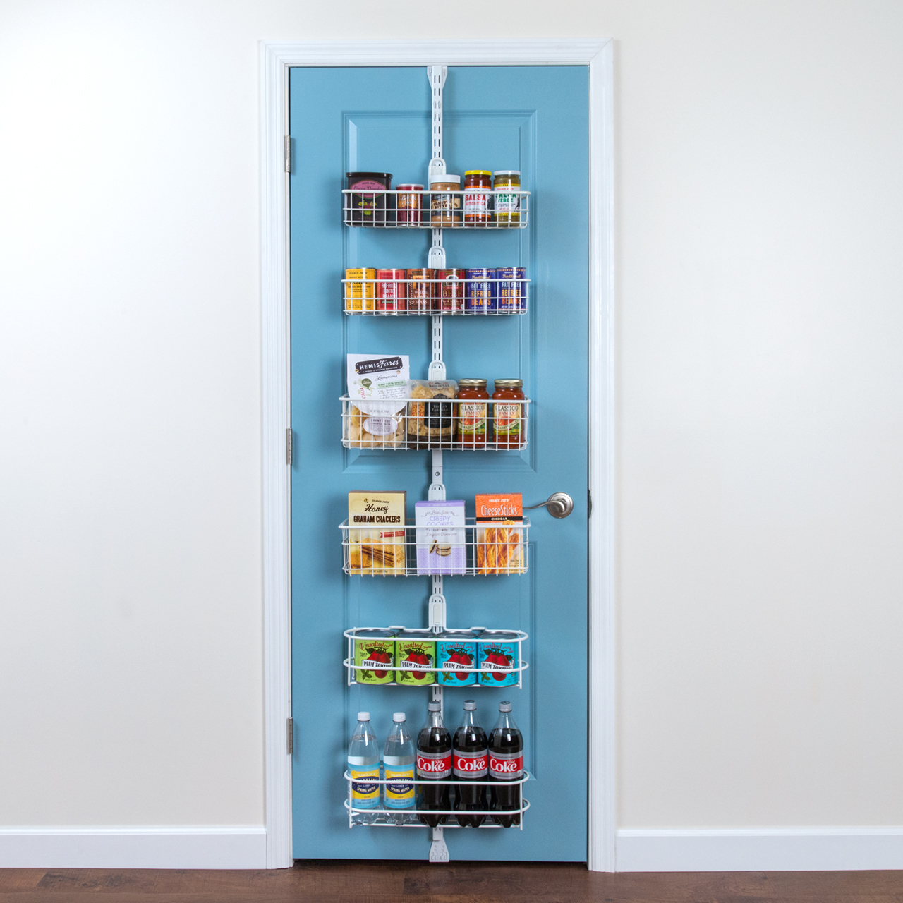 # Pantry Over the Door Kit with white baskets containing dried food boxes and canned goods on a blue door.